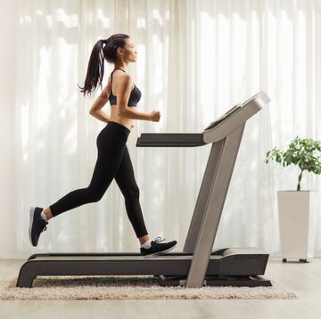 young woman running on a treadmill indoors