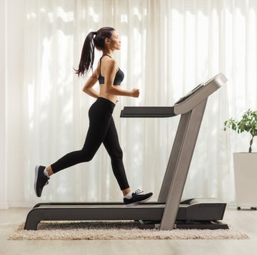 young woman running on a treadmill indoors