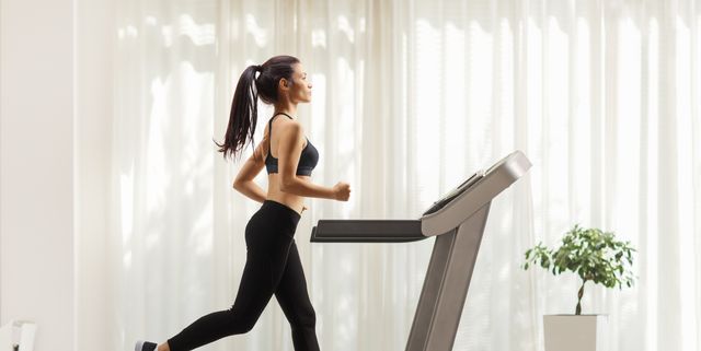 young woman running on a treadmill indoors