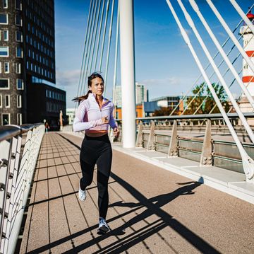 young woman running over the bridge by the river in malmo, sweden