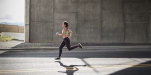 young woman running under freeway overpass