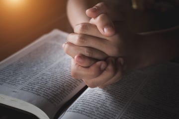 praying hands over bible