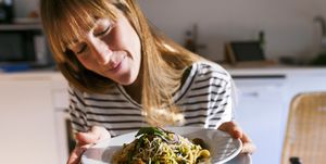 young woman serving vegan pasta dish