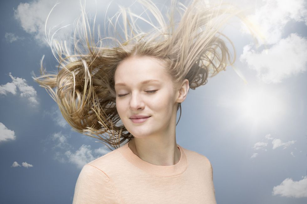 young woman shaking her hair in wind