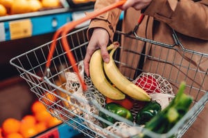 vrouw legt bananen in mandje