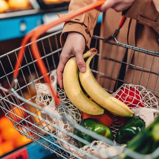 young woman shopping vegetables in supermarket