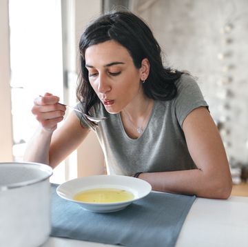 young woman eating broth