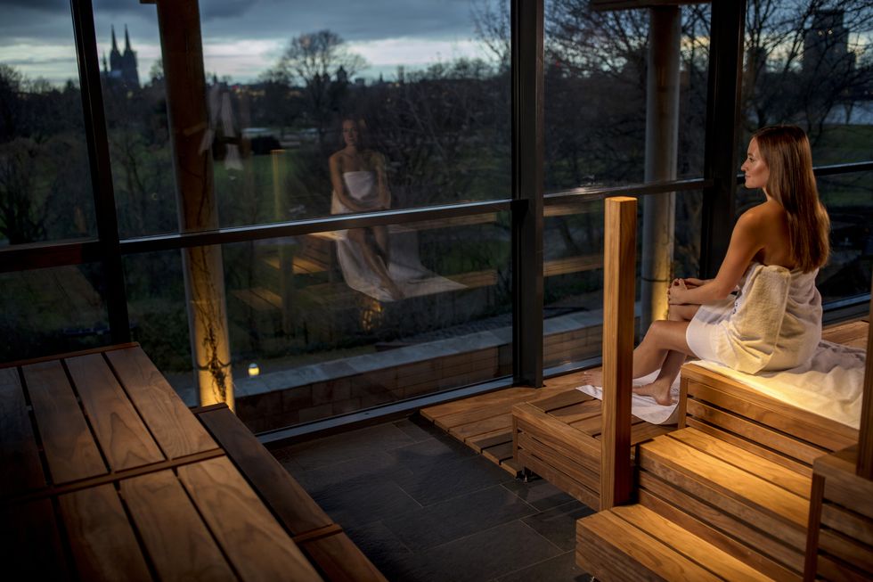 young woman sitting in a sauna with panoramic window