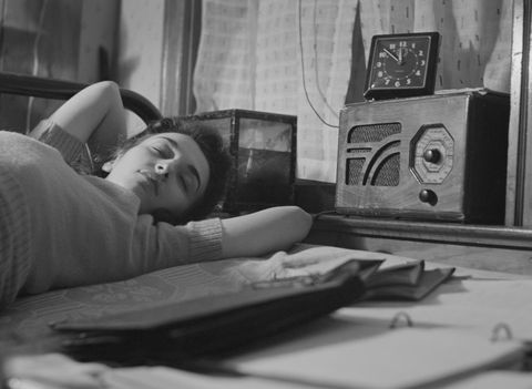 young woman sleeping while listening to radio in boardinghouse room, washington dc, january 1943