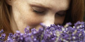young woman smelling lavendar, eyes closed, close up