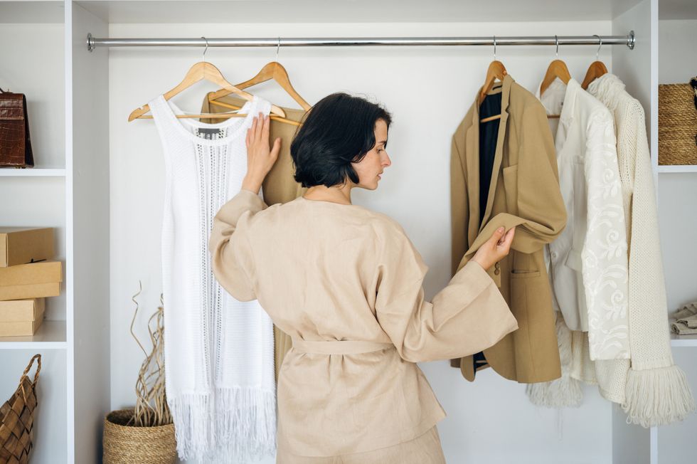 a woman looking through items in the wardrobe
