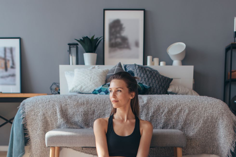 young woman stretches her legs with her knees apart.