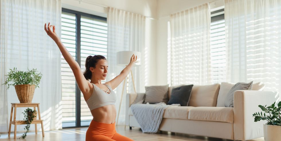 young woman taking exercise in her living room