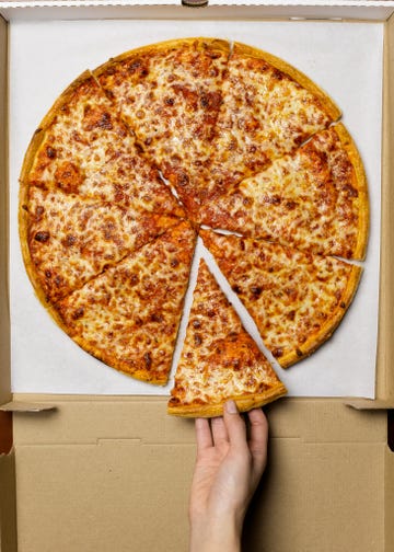Young woman taking slice of pizza, overhead view