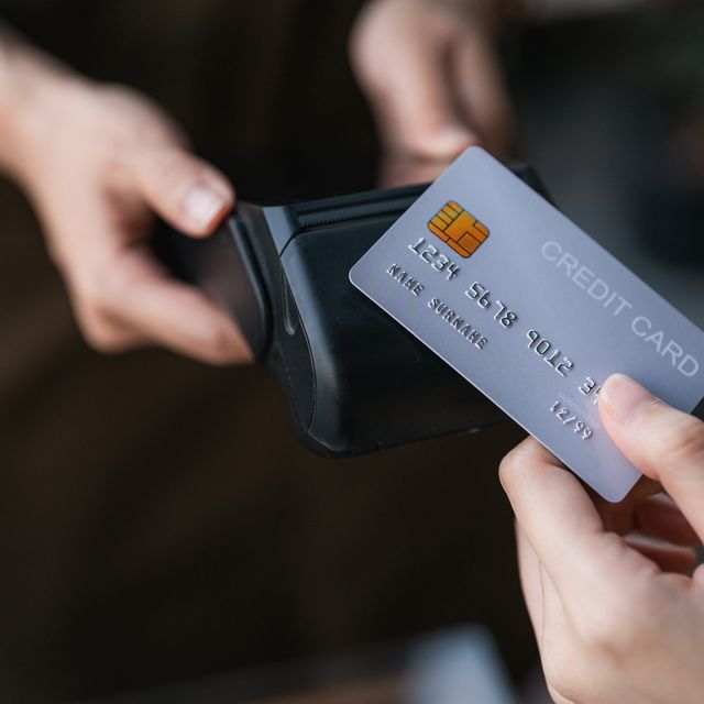 young woman tapping her credit card on the waitress's device, embracing the ease and speed of contactless payment
