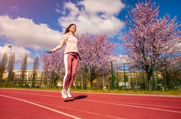 vrouw is aan het touwtjespringen op een atletiekbaan