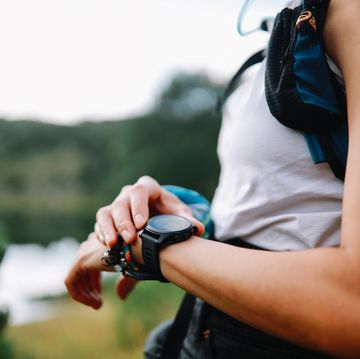 young woman using a smart watch during the hiking trip