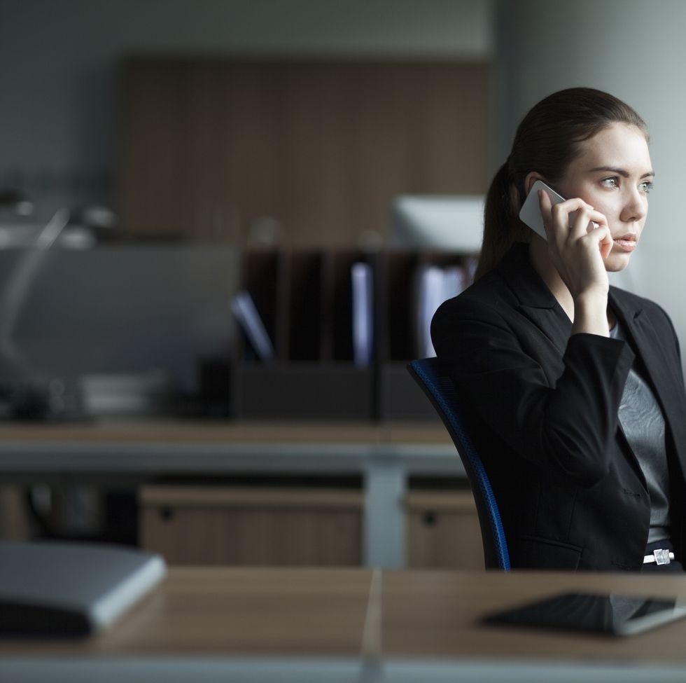 young woman using cell phone in business office