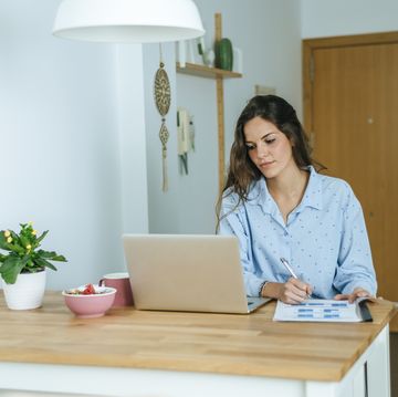 young woman using laptop during breakfast at home
