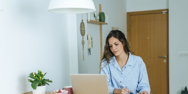 young woman using laptop during breakfast at home