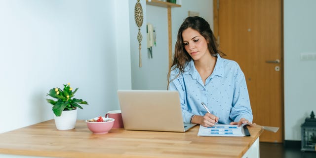 young woman using laptop during breakfast at home