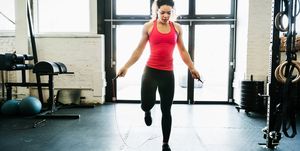 young woman using skipping rope to keep fit