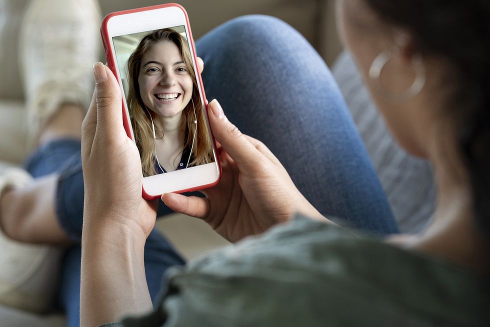 young woman using smartphone for video call