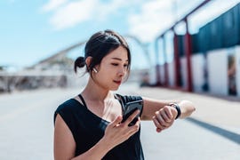 young woman using smartwatch and doing outdoor workout in the city