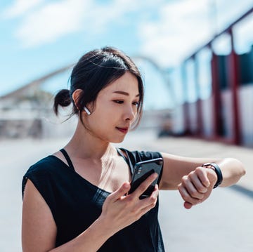 young woman using smartwatch and doing outdoor workout in the city