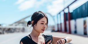 young woman using smartwatch and doing outdoor workout in the city