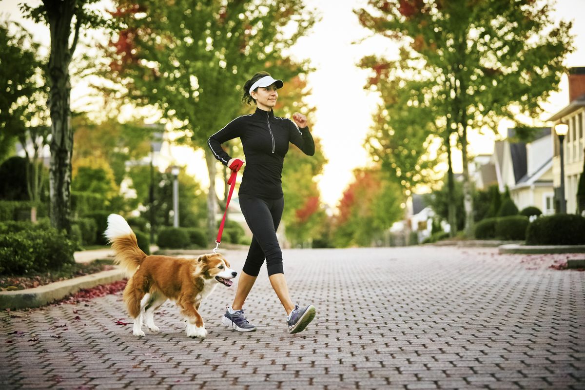 walking workouts for runners, young woman walking dog