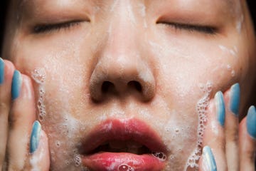 young woman washing face, close up