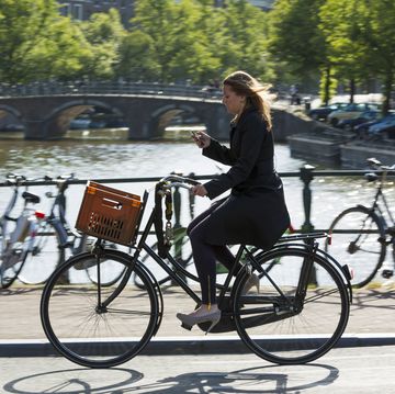 Young Woman Cycling on Bridge in Amsterdam, Holland