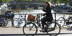Young Woman Cycling on Bridge in Amsterdam, Holland