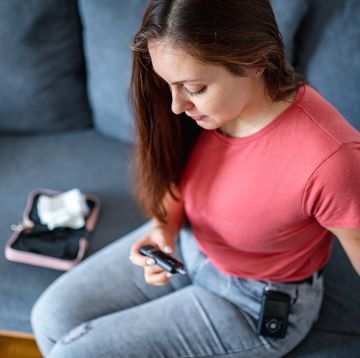 young woman wearing insulin pump and checking glucometer