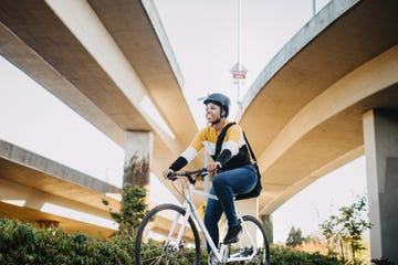 young woman with bike and messenger bag in the city