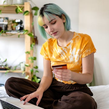 Young woman with colored hair is shopping online with a credit card young woman with colored hair is shopping online with a credit card