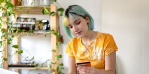 young woman with colored hair is shopping online with a credit card