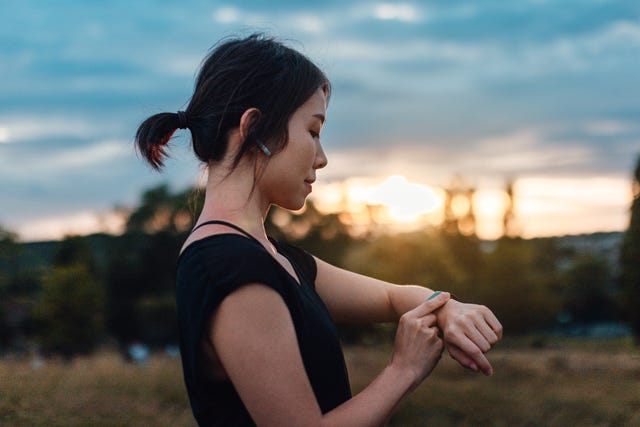 young woman with earphones and smart watch