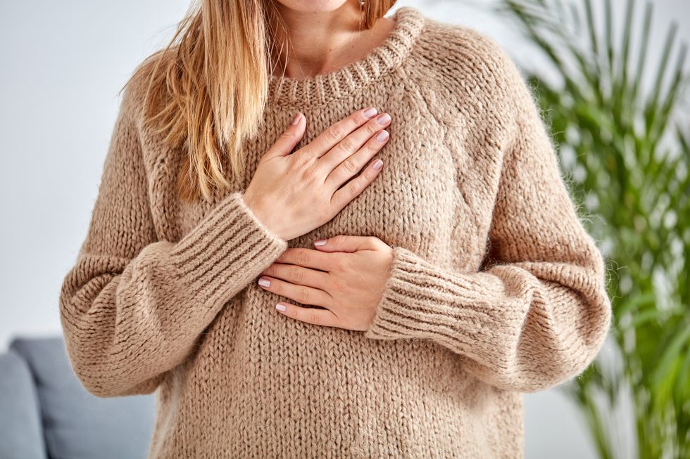 young woman with heart problem holding chest
