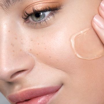 Young woman with perfect skin applying foundation