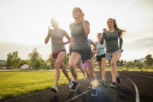 young women runners rounding turn on track