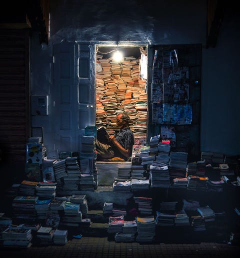 Torens van boeken omringen een winkelier in Rabat de hoofdstad van Marokko