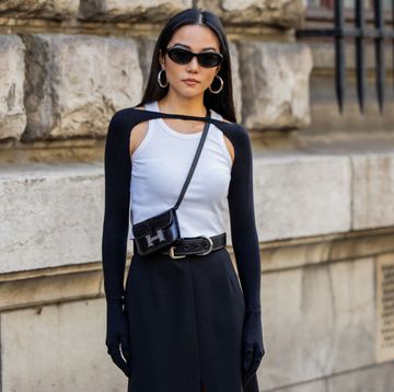 yoyo cao poseert in witte tanktop zwarte bolero schoudertas zonnebril en oorbellen tijdens fashion week