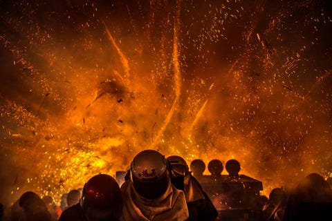 https://www.nationalgeographic.com/content/dam/travel/2018-digital/fireworks-around-the-world/ys-fireworks-12.jpg TaiwanMoedige toeschouwers met helmen op trotseren exploderende bijenkorven die zijn gevuld met duizenden vuurpijlen Wie tijdens het bijenkorfvuurwerkfestival van Yanshui in Taiwan door een vuurpijl wordt geraakt voelt zich gezegend
