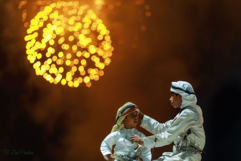 https://www.nationalgeographic.com/content/dam/travel/2018-digital/fireworks-around-the-world/ys-fireworks-17.jpg OmanTerwijl de lucht boven de stad Masqat door vuurwerk wordt verlicht doet een moment van genegenheid tussen twee jonge broers in traditionele kledij fotograaf Abdul Azeez Pulikkool denken aan een bijbels tafereel