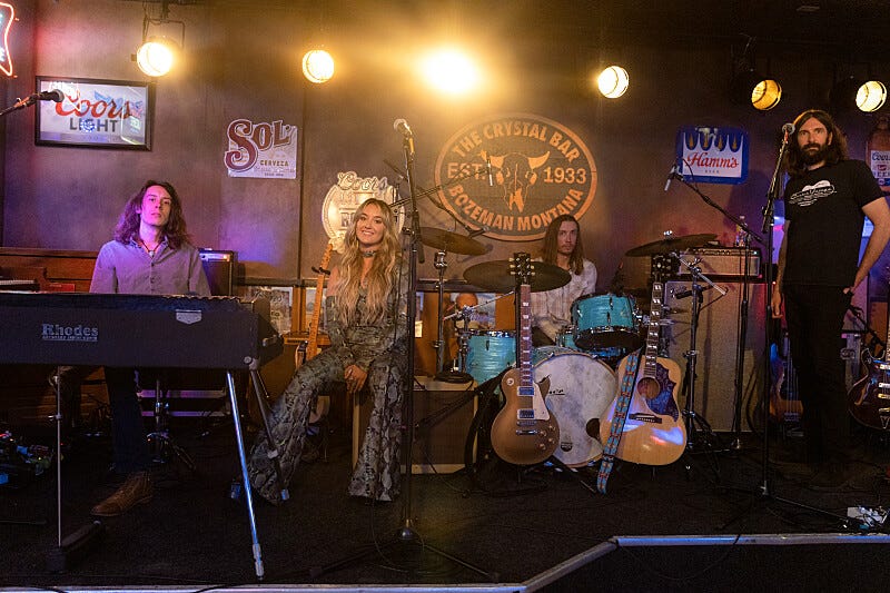 musicians performing on stage in a bar setting