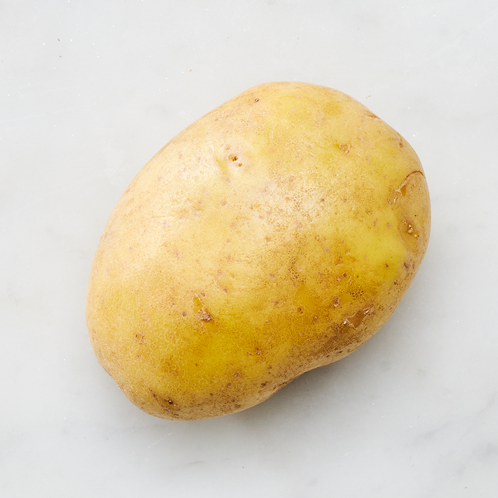 whole yukon gold potato on a light background