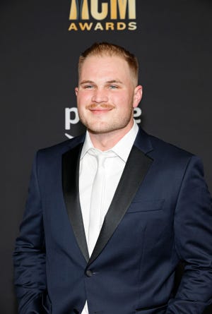 zach bryan stops for a photo at the academy of country music awards