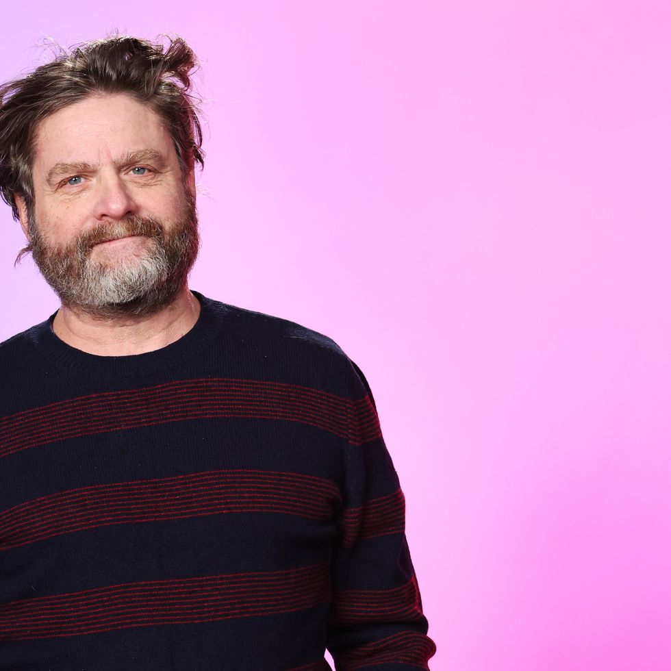 zach galifianakis standing in front of a purple background